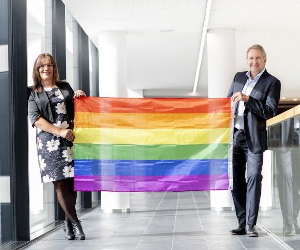 Foto von Nina Meyer und Dr. Brick. Sie halten einen Regenbogenflagge.